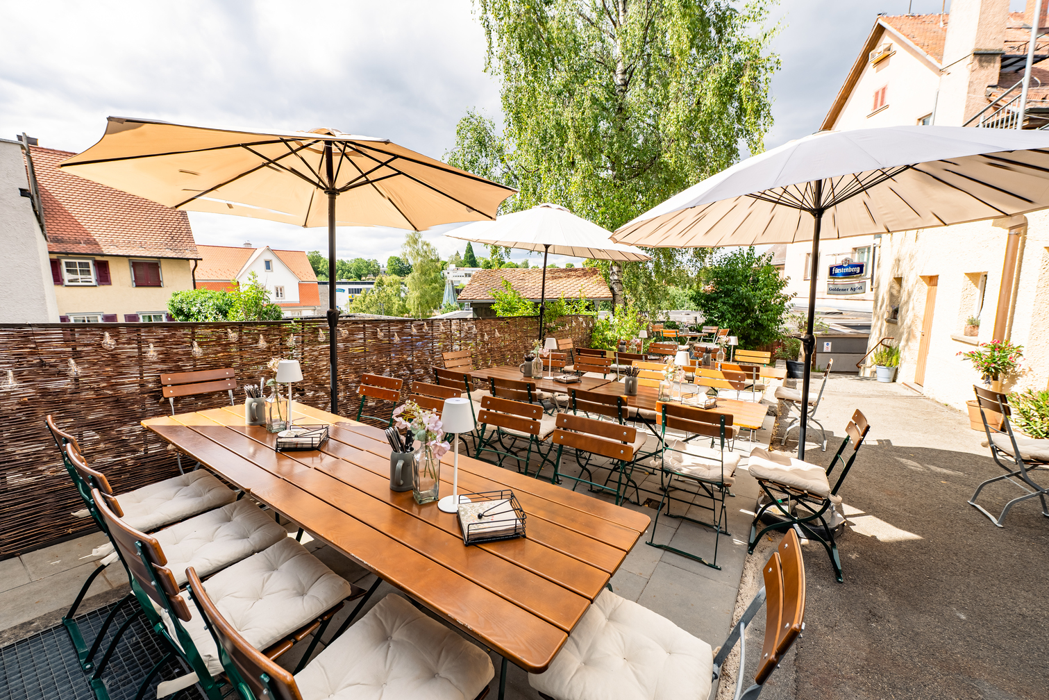 Sonnige Terrasse mit Biergartentischen